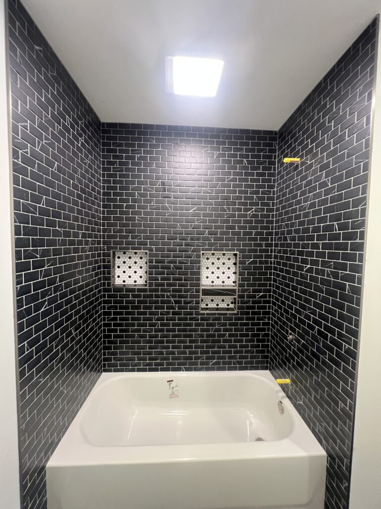 Black marble tile shower by Palacios Installation