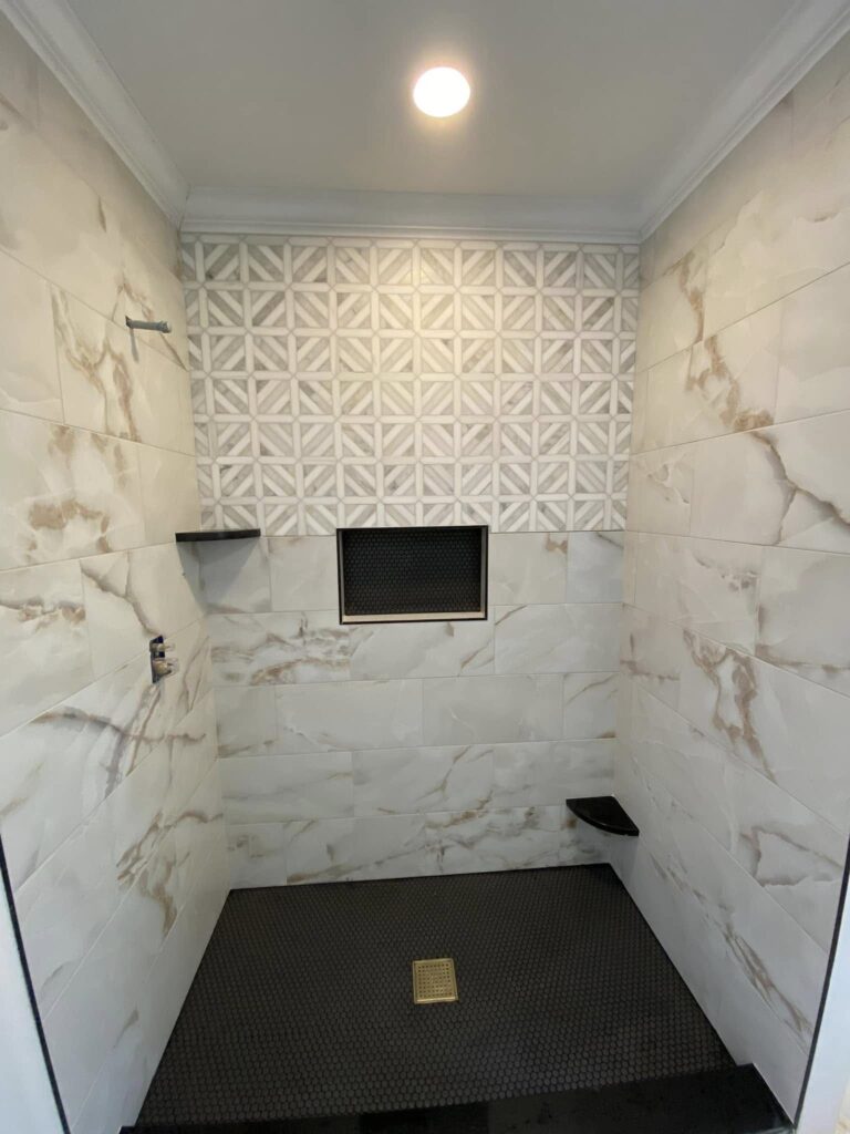Marble-look tile shower with a geometric accent wall, Chattanooga, TN by Palacios Installation