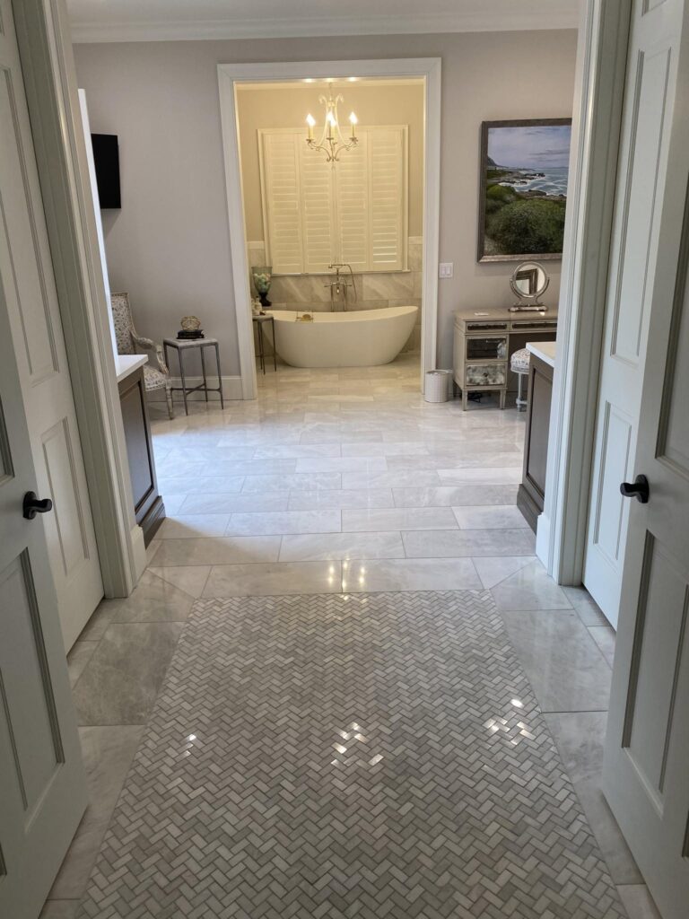 Master bathroom with a herringbone marble tile floor and freestanding tub, Chattanooga, TN by Palacios Installation